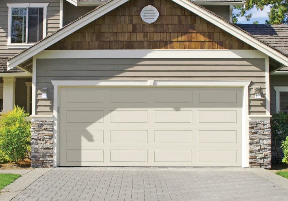 Almond long-panel double garage door framed by stone columns