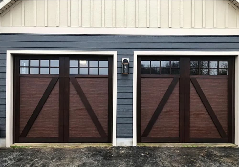 Dark walnut carriage-style garage doors with crossbuck detailing and multi-pane windows