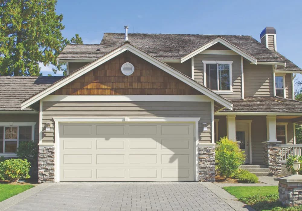 White long-panel garage doors with window tops on a two-story home